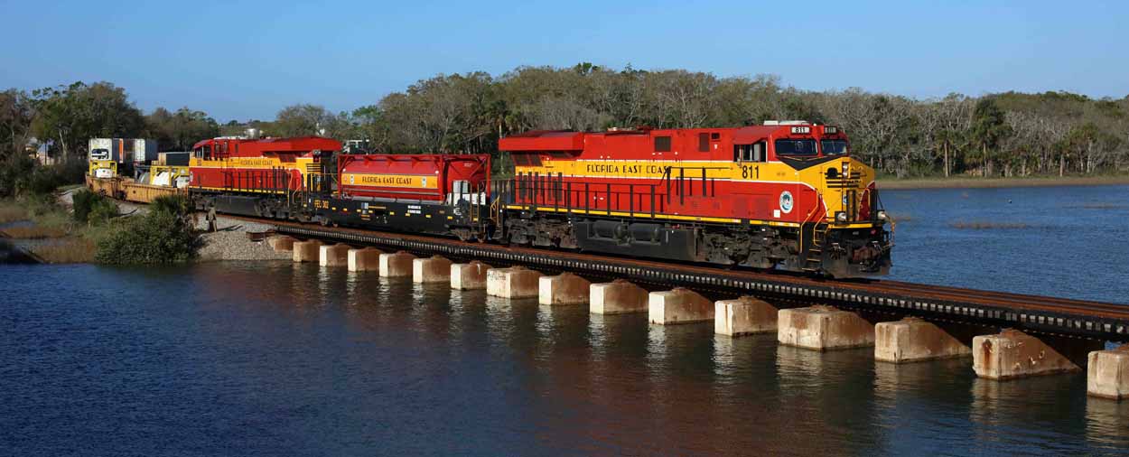 Florida East Coast Railway 811 and 803 sandwich FEC LNG tender 302, taking northbound intermodal train 226 (Hialeah Yard - Bowden Yard) across the San Sebastian River on 11 March 2017.